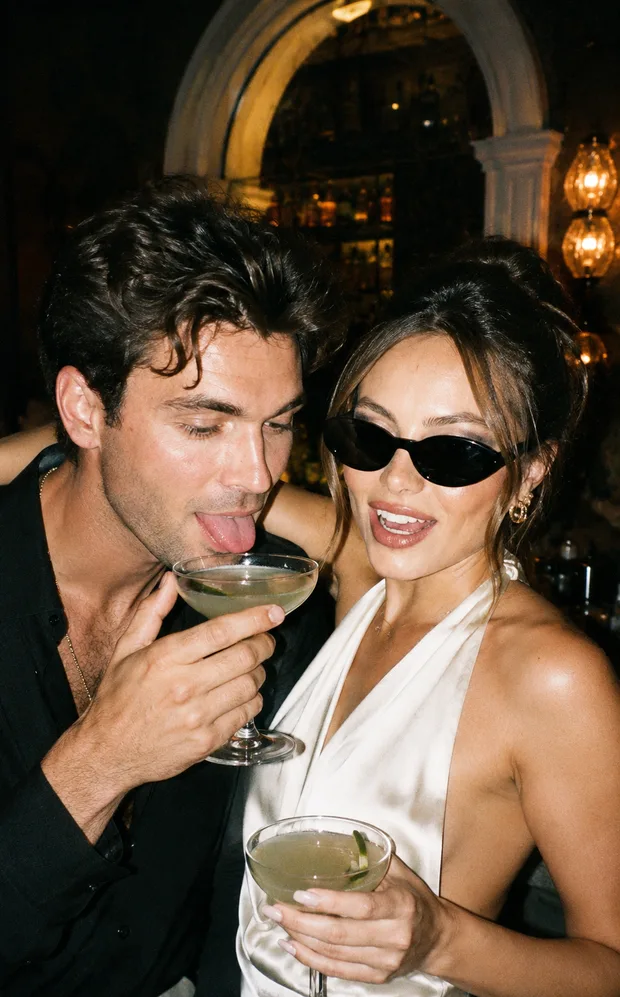 A couple laughing over cocktails at a bar