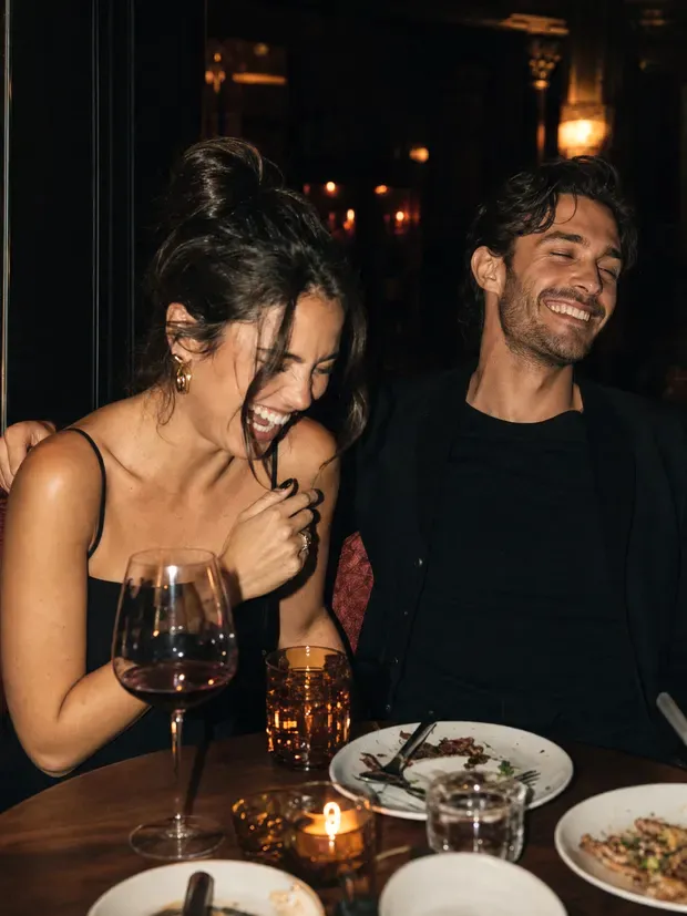 Couple laughing over a candlelit dinner date